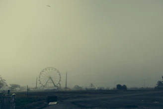 A haunted carnival tent with eerie fog and twisted carnival rides.