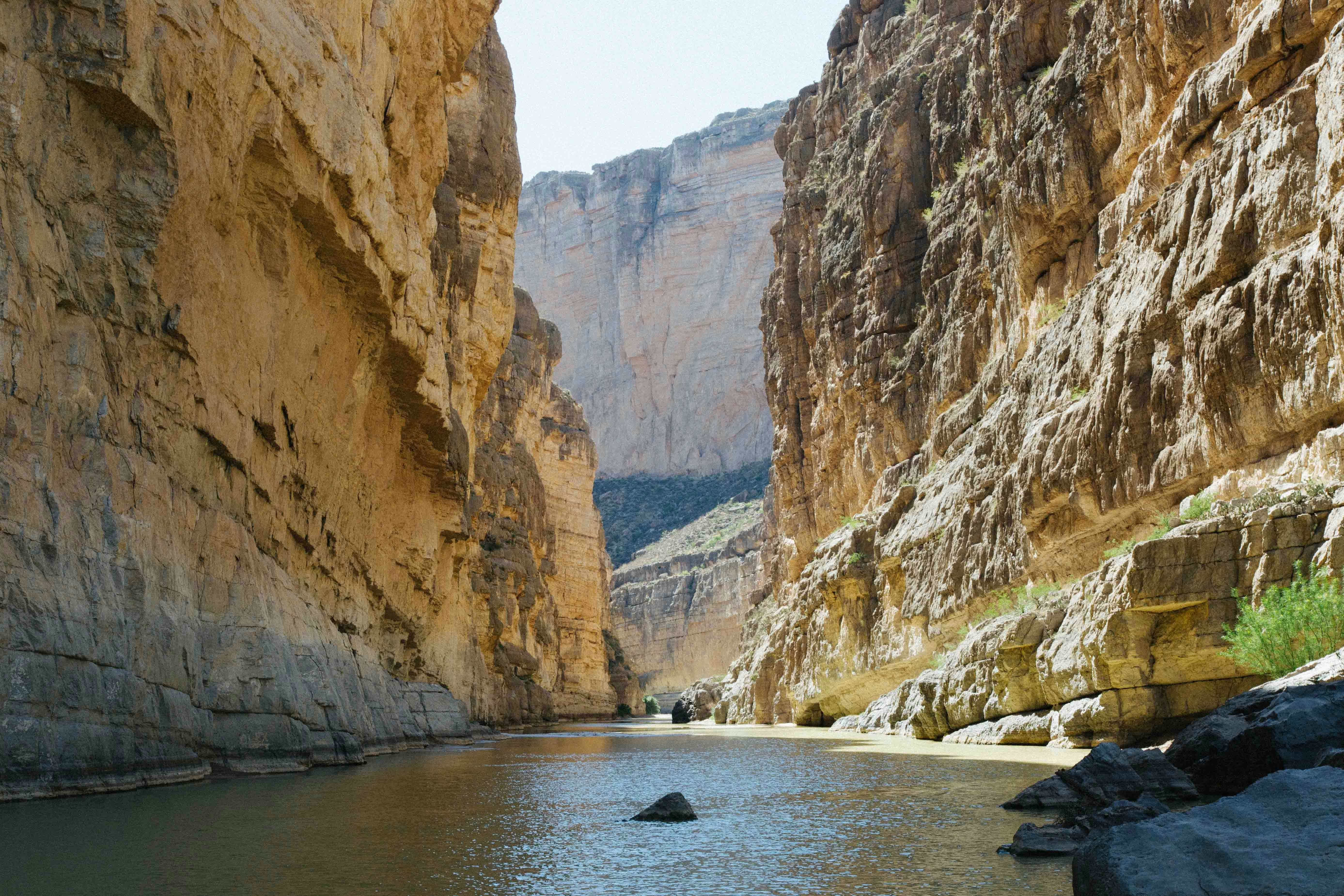 river between rocky mountains under clear sky