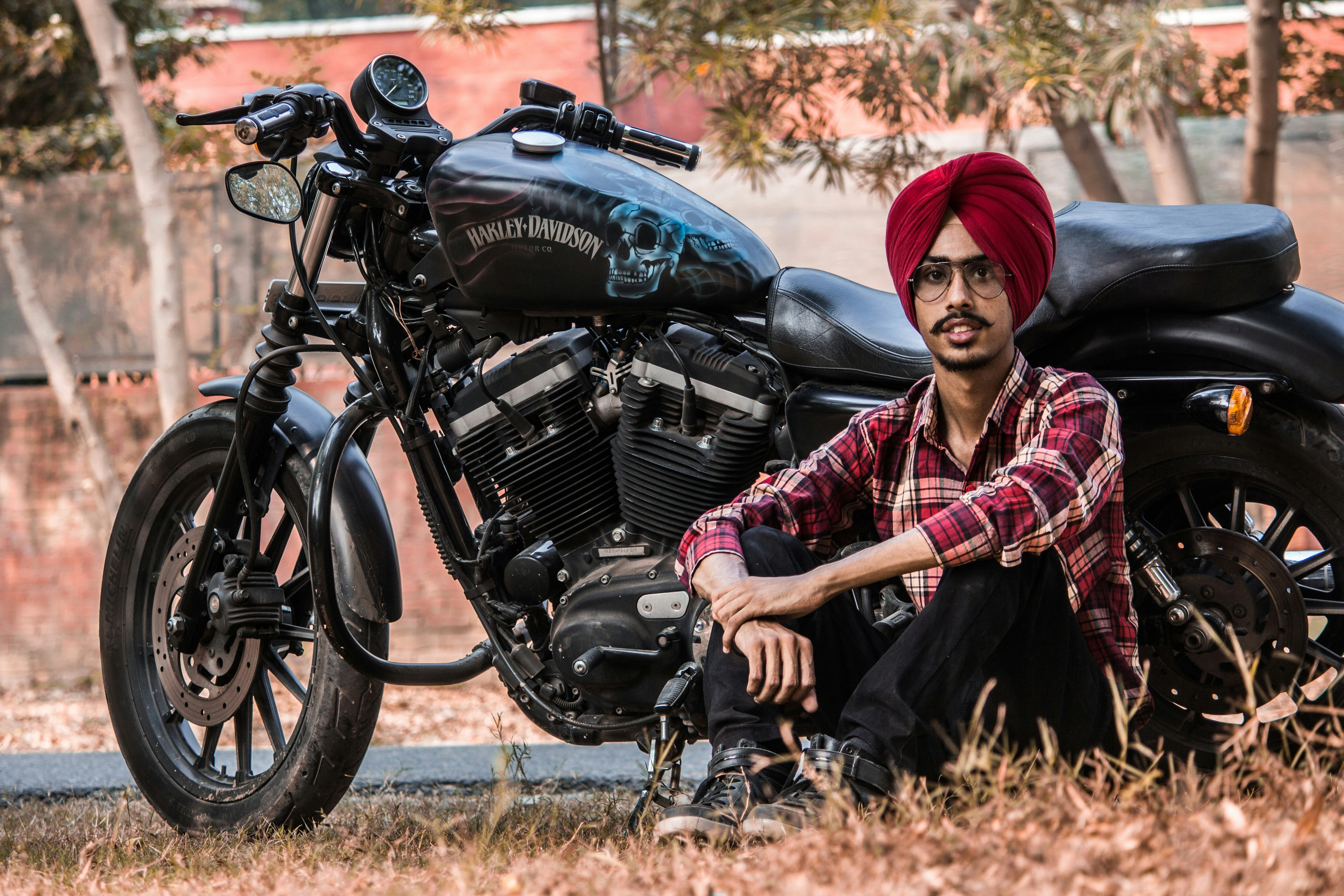 man sitting beside black standard motorcycle