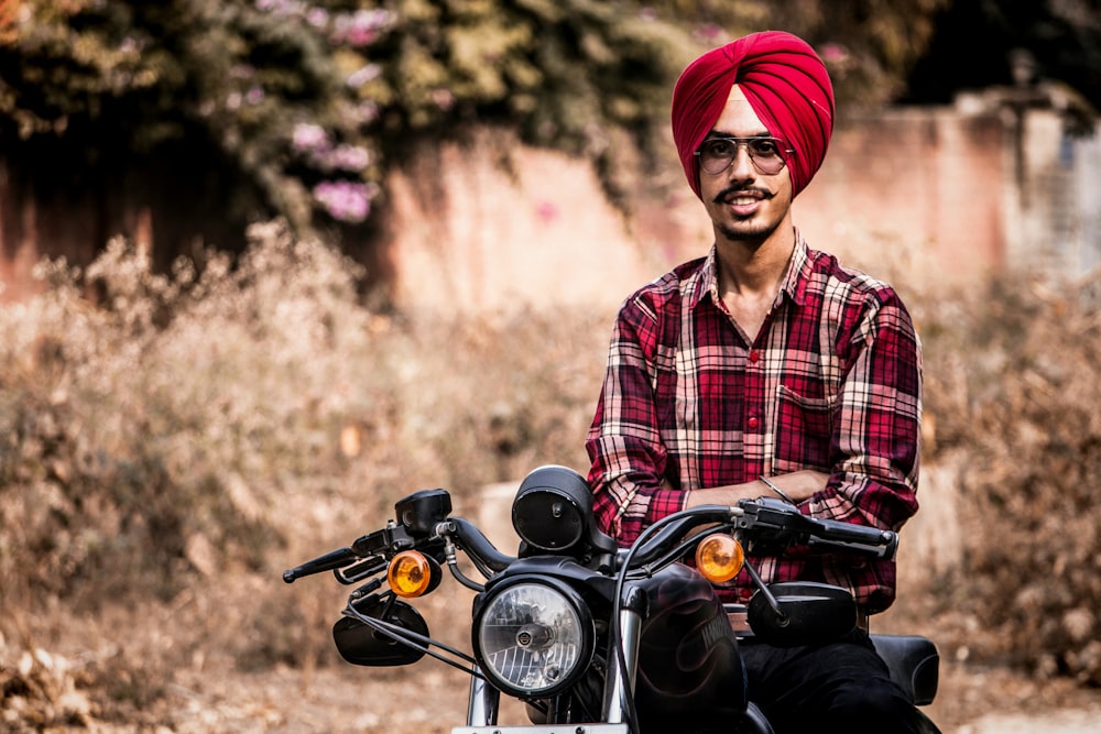 man riding on motorcycle near dried grass