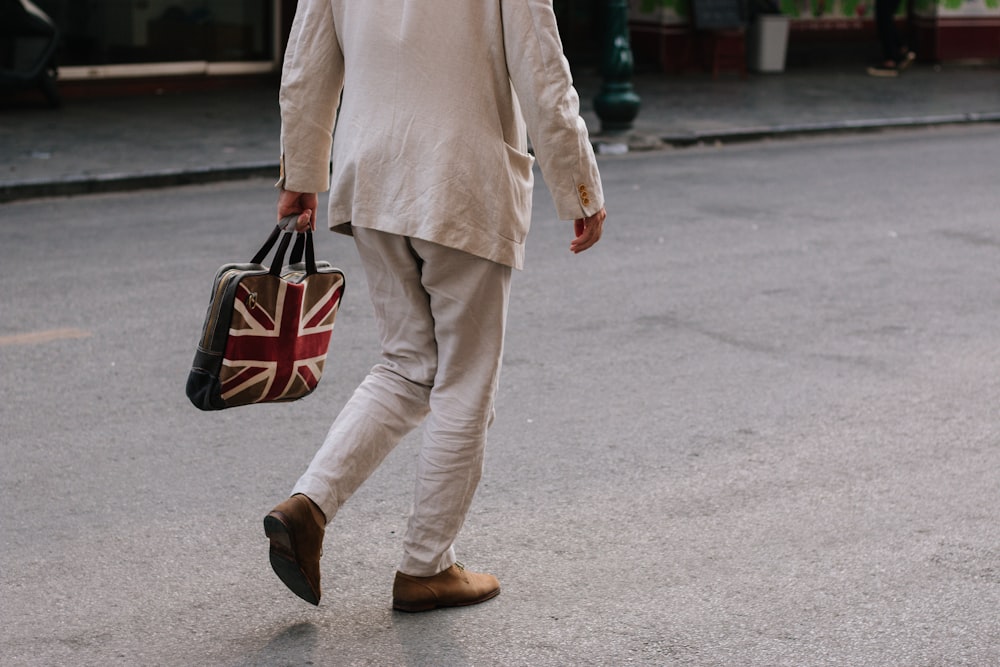 man walking while holding handbag