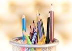 shallow focus photography of pencils on desk rack