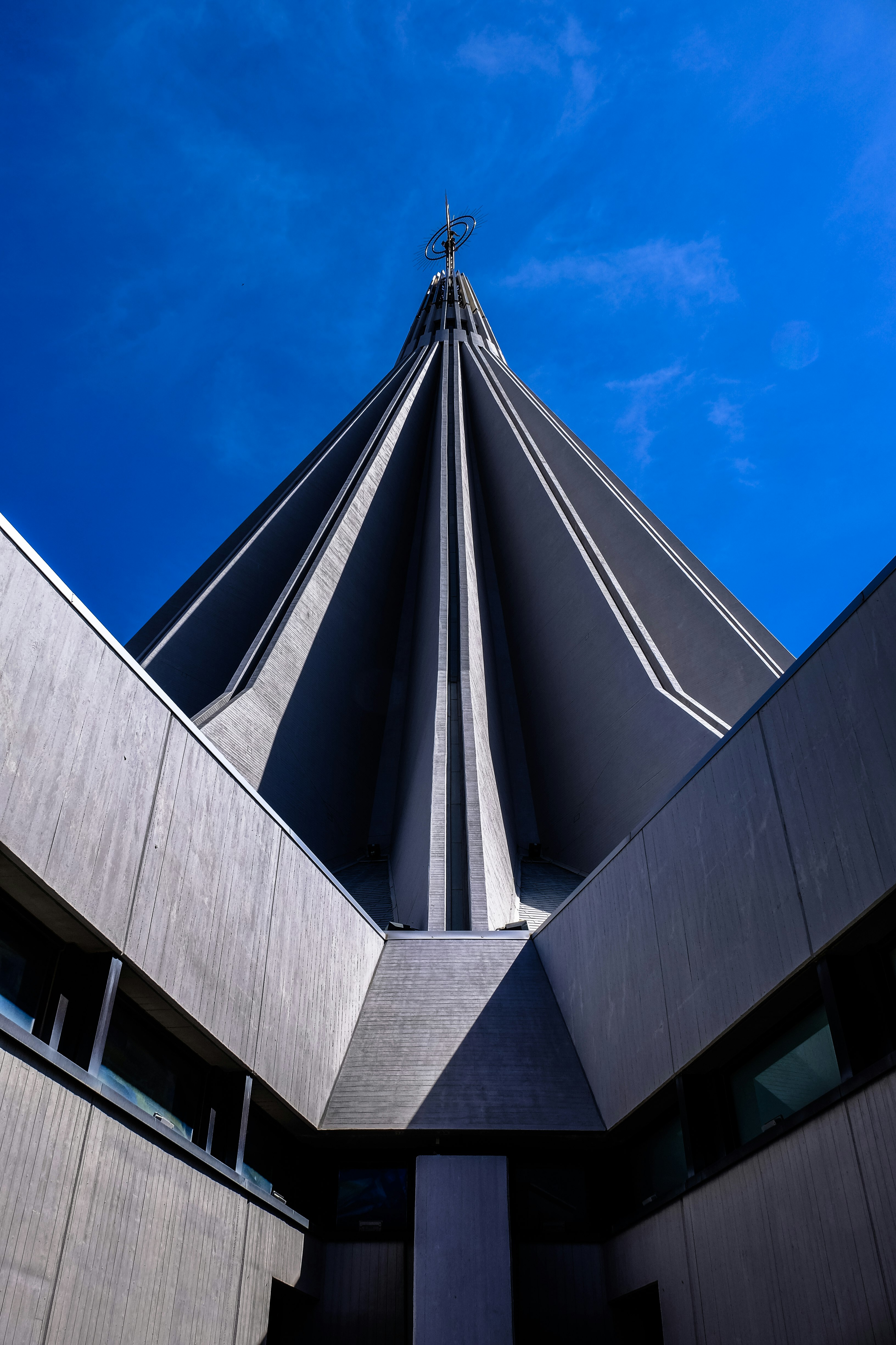 gray concrete building with circle finial under clear sky