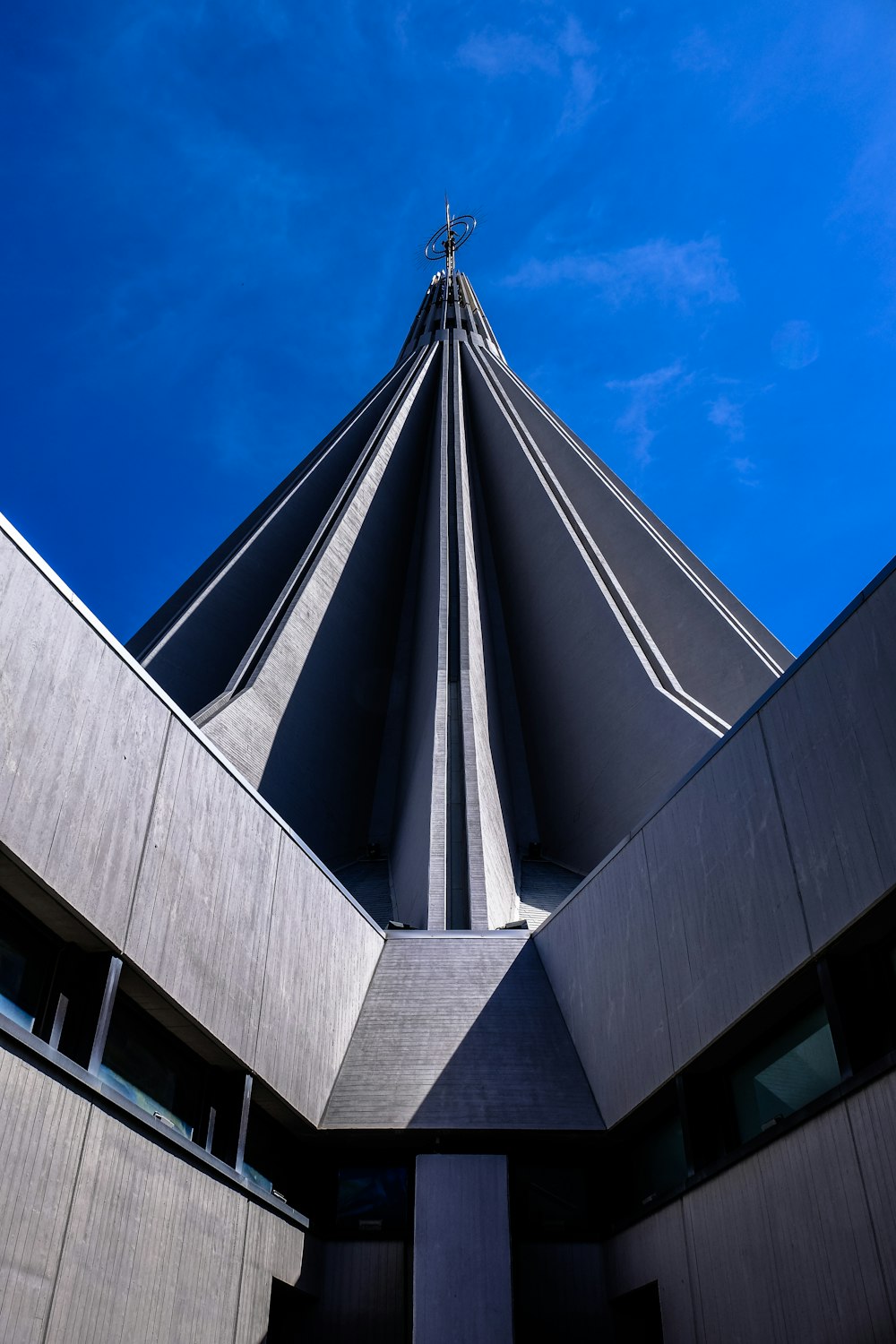 gray concrete building with circle finial under clear sky