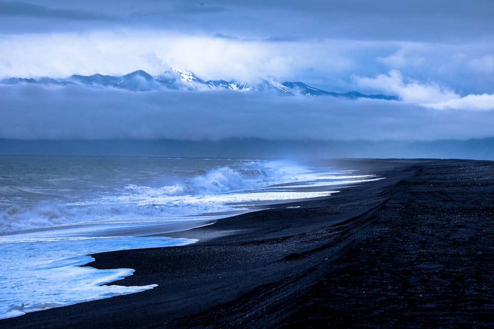 seashore under white clouds during daytime