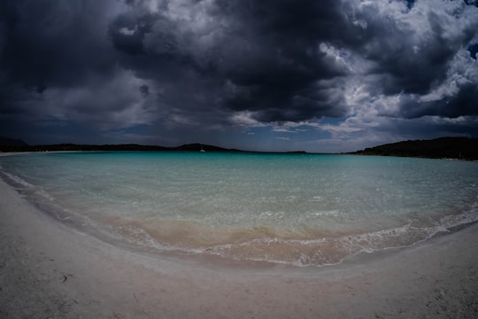 sea wave splashing on white sand seashore in Sardinia Italy