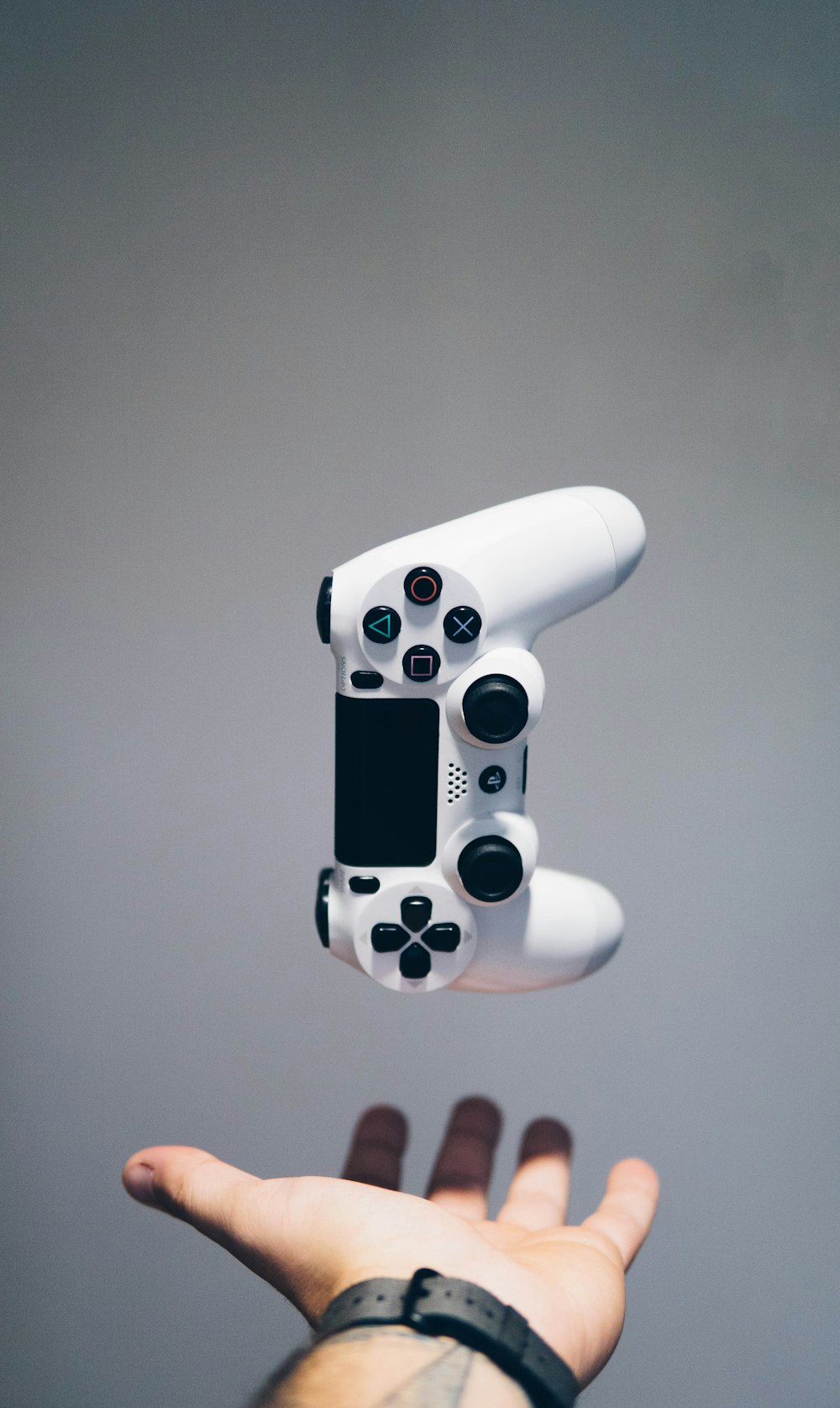 weißer Sony PS4 DualShock-Controller über der Handfläche der Person