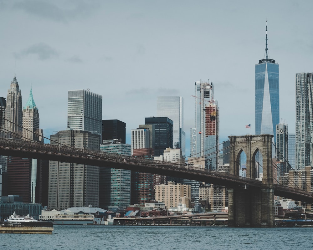 Brooklyn bridge with body of water under gray sky during daytime