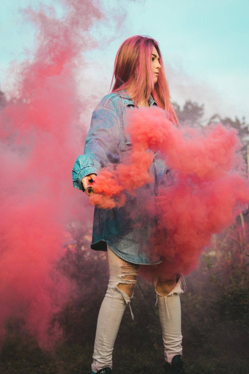 Mujer sosteniendo humo rojo