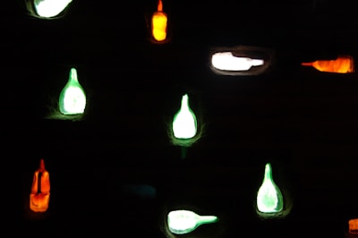 Futuristic potion bottles emitting colorful light on a sleek black surface