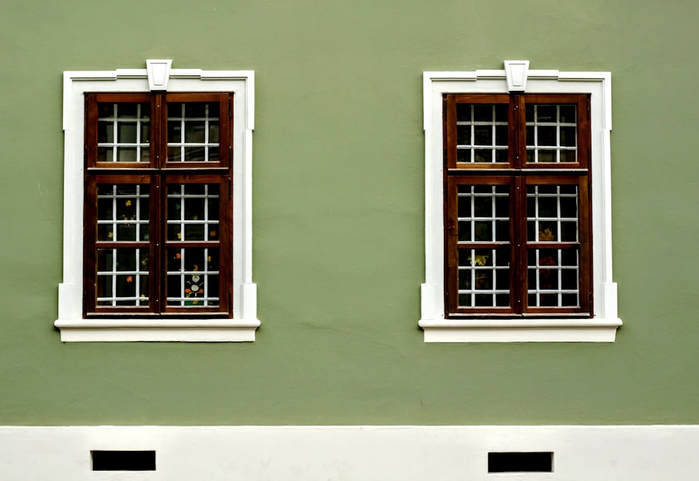 brown windows mounted in green painted wall