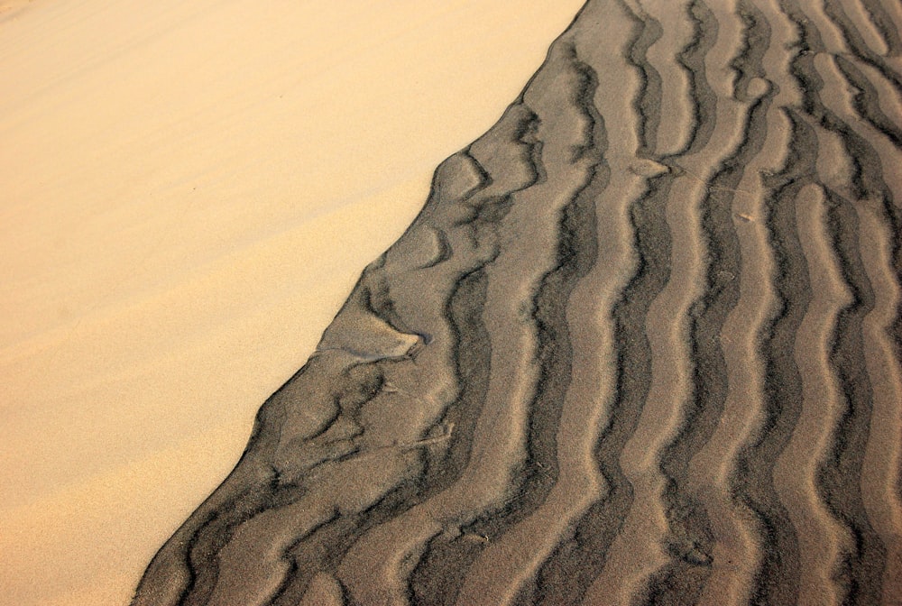 uma duna de areia com linhas onduladas na areia