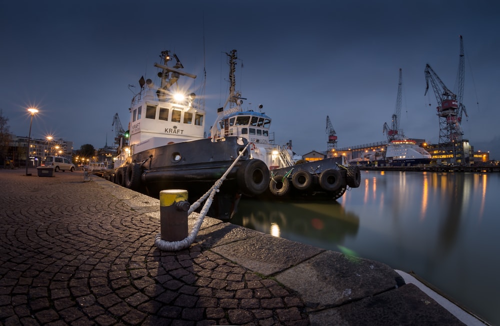 two white sailboats docked beside post light during nighttime