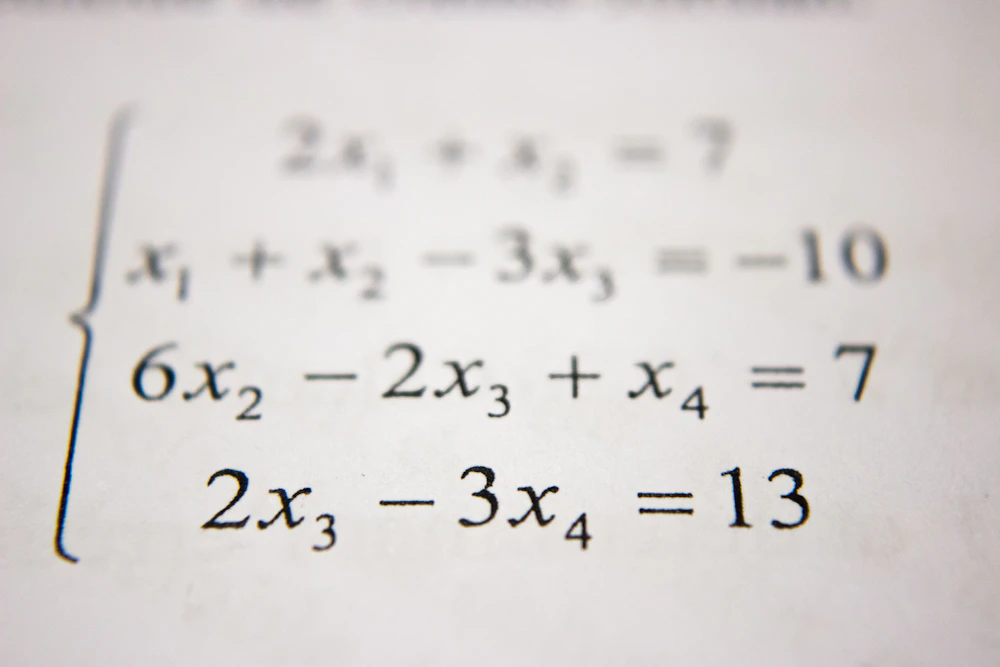 Student solving fraction problems on a whiteboard