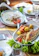 A cozy table setting with fresh grilled fish and blue-white themed decor.