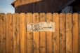 brown wooden plank fence with this way signboard