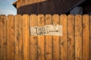 brown wooden plank fence with this way signboard