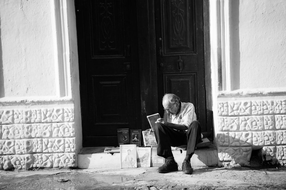 man sitting on white tile floor near door