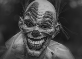 grayscale photography of person wearing clown mask