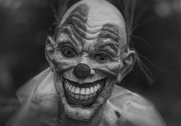 grayscale photography of person wearing clown mask