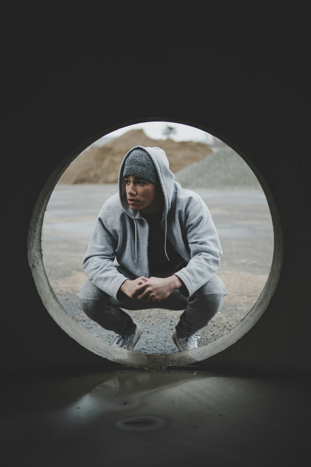 man sitting near gray tunnel during daytime