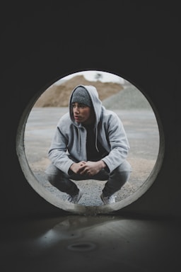 framing with frames for photo composition,how to photograph holy; man sitting near gray tunnel during daytime