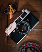 Vintage UBM Canon camera displayed with film rolls and photography accessories.