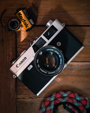 Vintage UBM Canon camera displayed with film rolls and photography accessories.