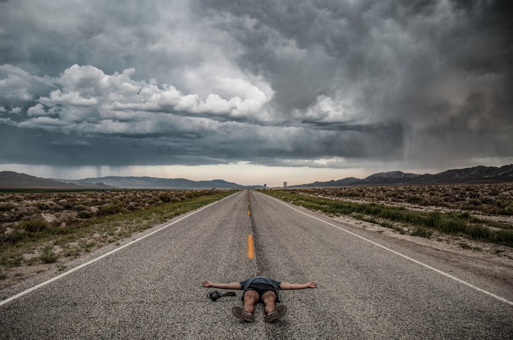personne de photographie allongée sur la route