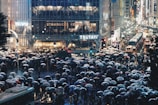 A bustling Shibuya crossing filled with colorful umbrellas under a soft rain.