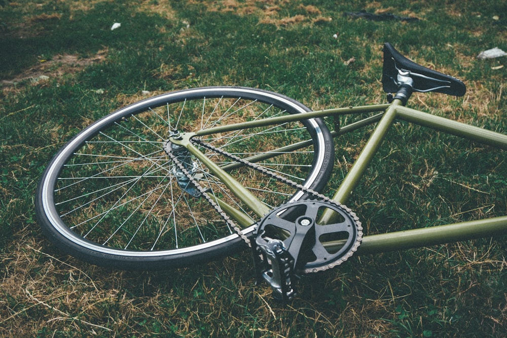 Bicicletta giù sul campo di erba verde