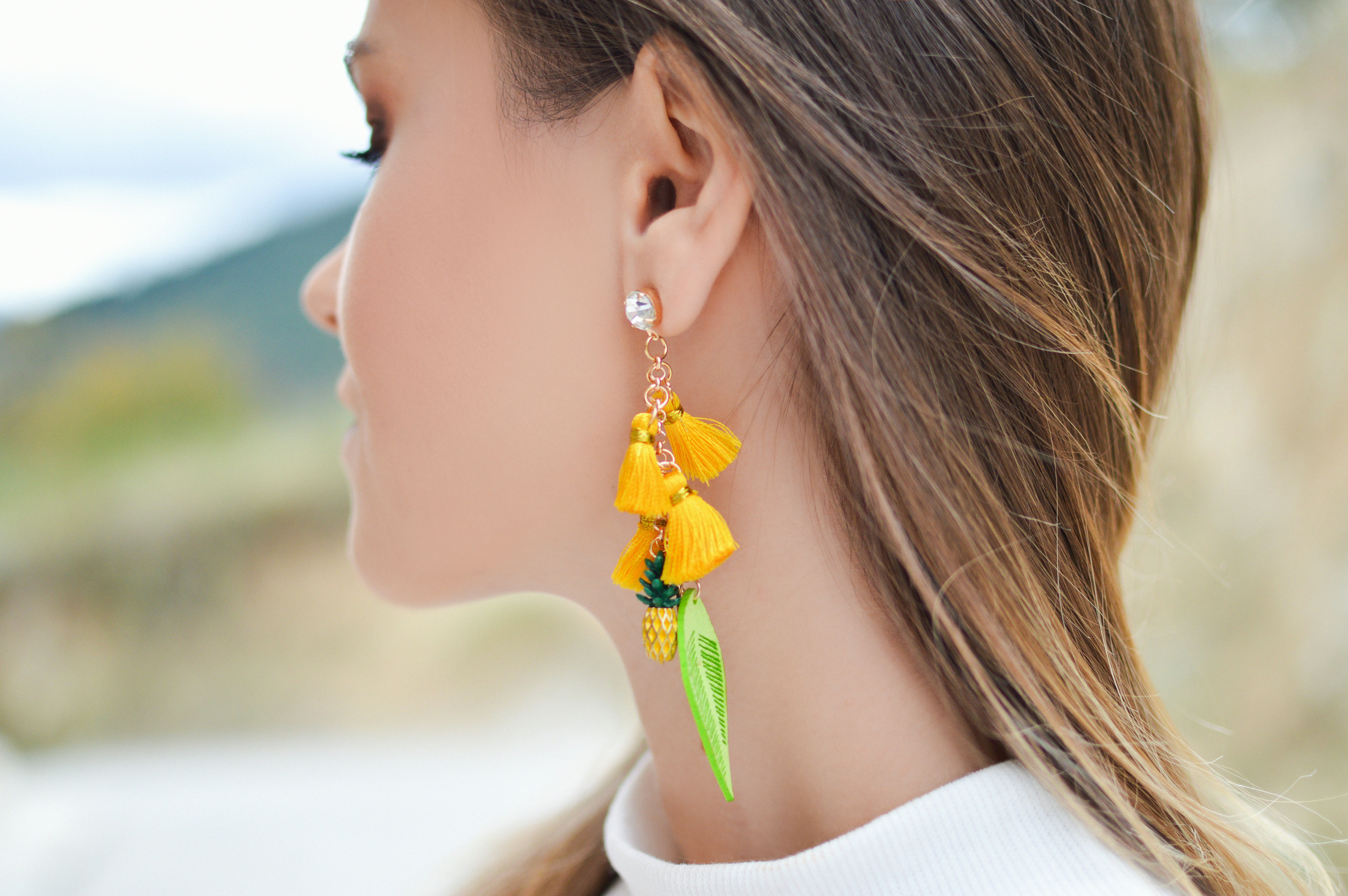 woman with yellow and green tasseled earring