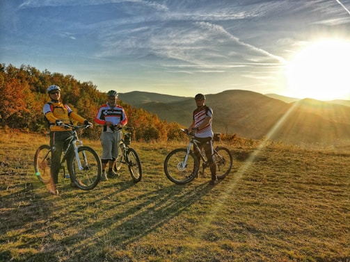A group of triathletes smiling and chatting after a training session at sunset.