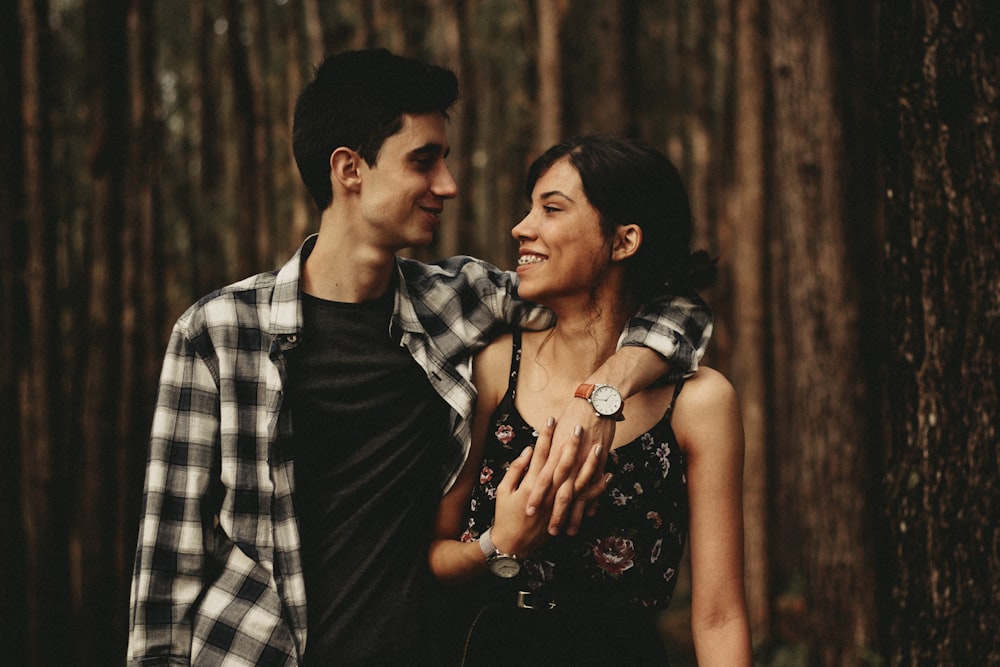 man wrapping arm on woman facing each other