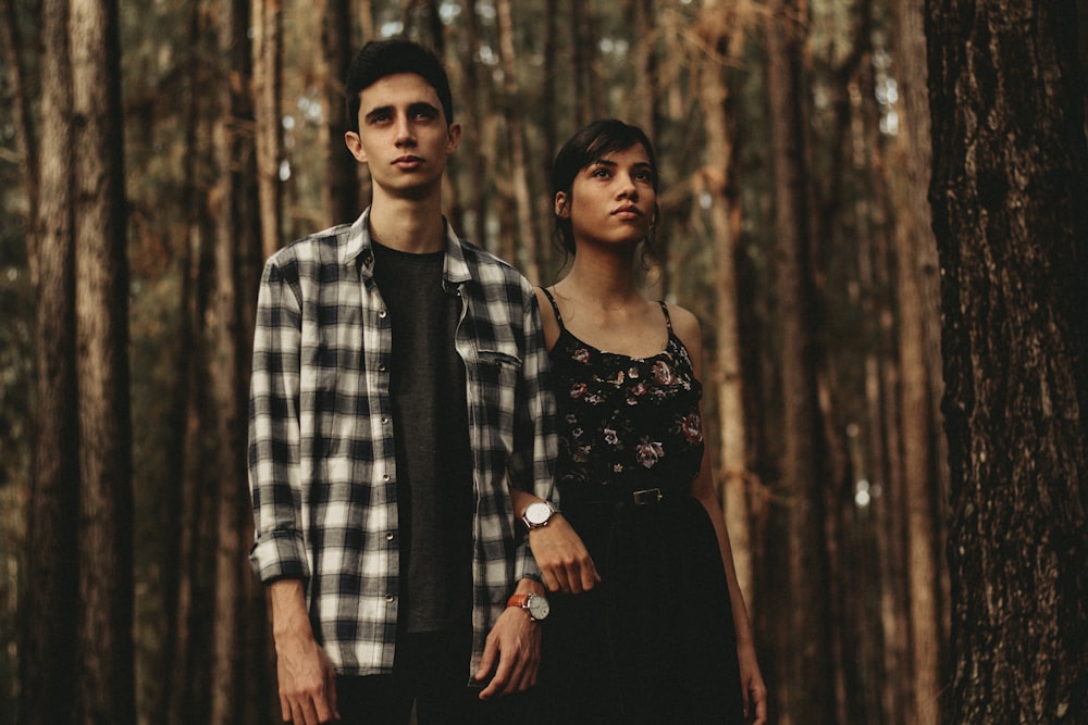 Hombre y mujer de pie uno al lado del otro en el bosque