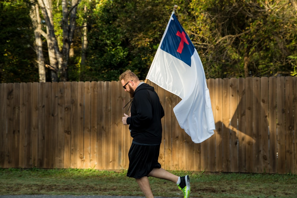 man in black jacket holding flag
