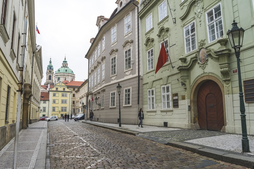 woman walking on street with red flag above her