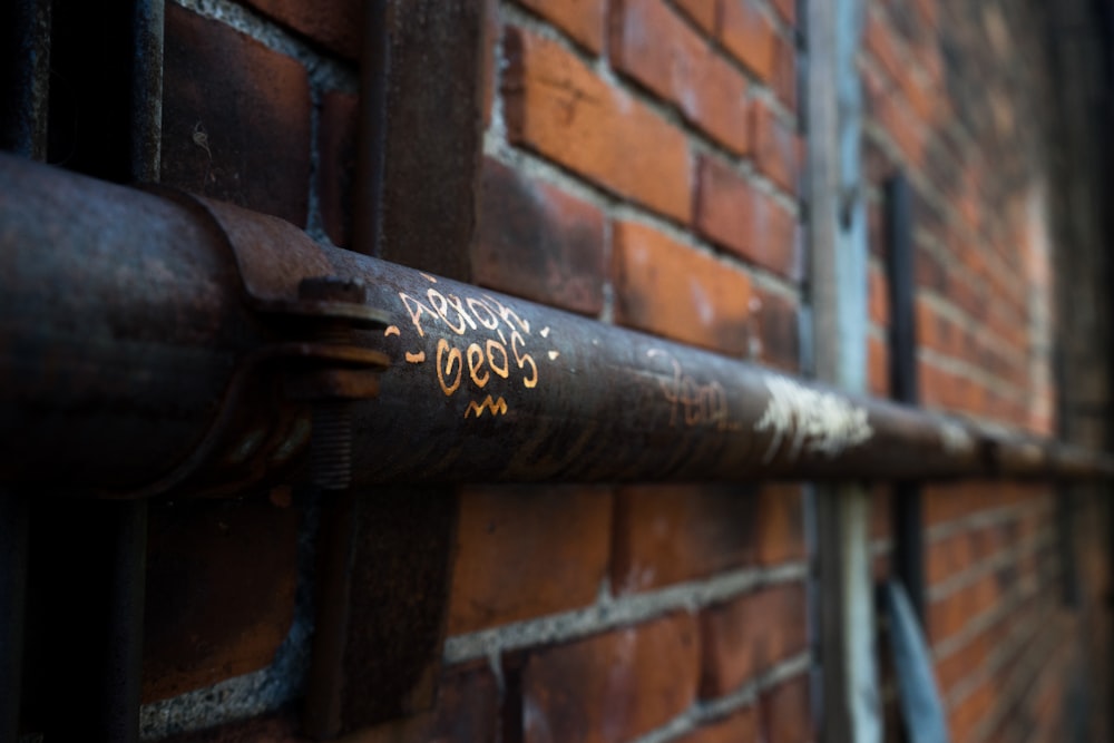 a close up of a metal pipe on a brick wall