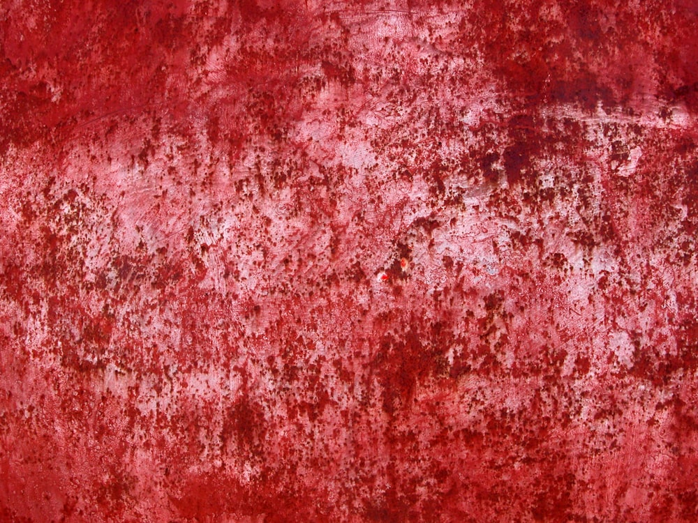 a red wall with a lot of rust on it