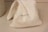 A small, folded cloth bag with the word 'GRAINGER' printed in black letters. It rests on a smooth, light-colored surface with shadows indicating soft lighting.