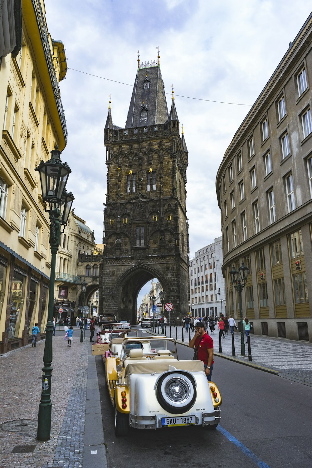 Mann steht neben dem Oldtimer, der neben der Straße geparkt ist