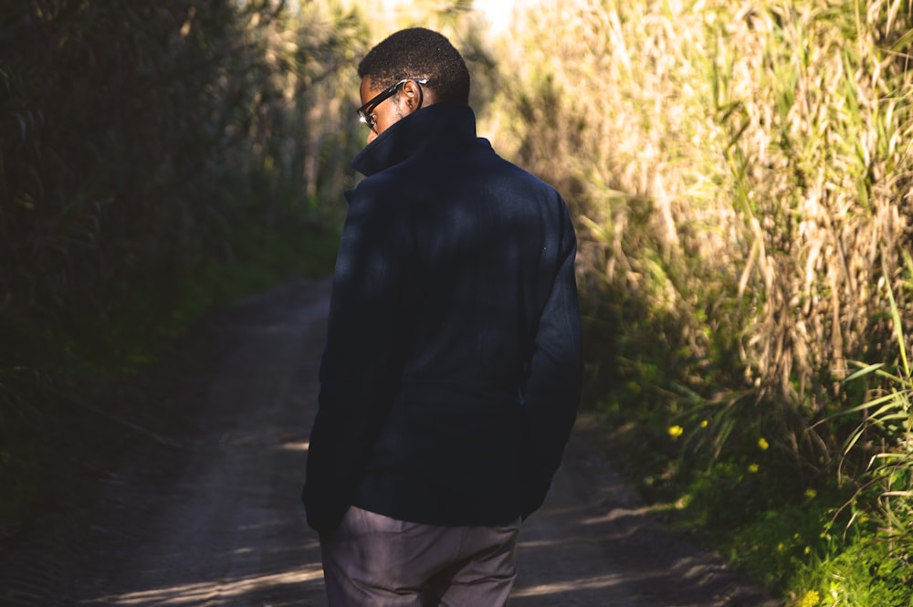 man walking near green leafed plants