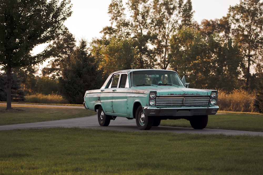 photo of green sedan on gray concrete floor