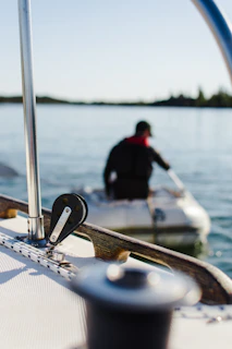 Hands tightening bolts on a boat’s structural frame with tools laid out neatly.
