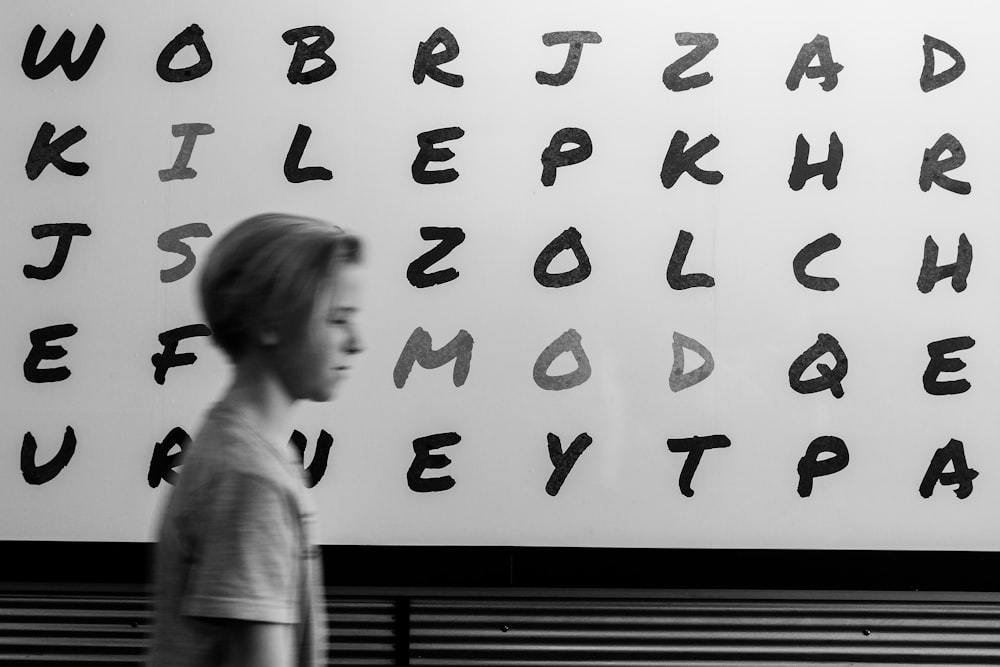boy standing in alphabet board