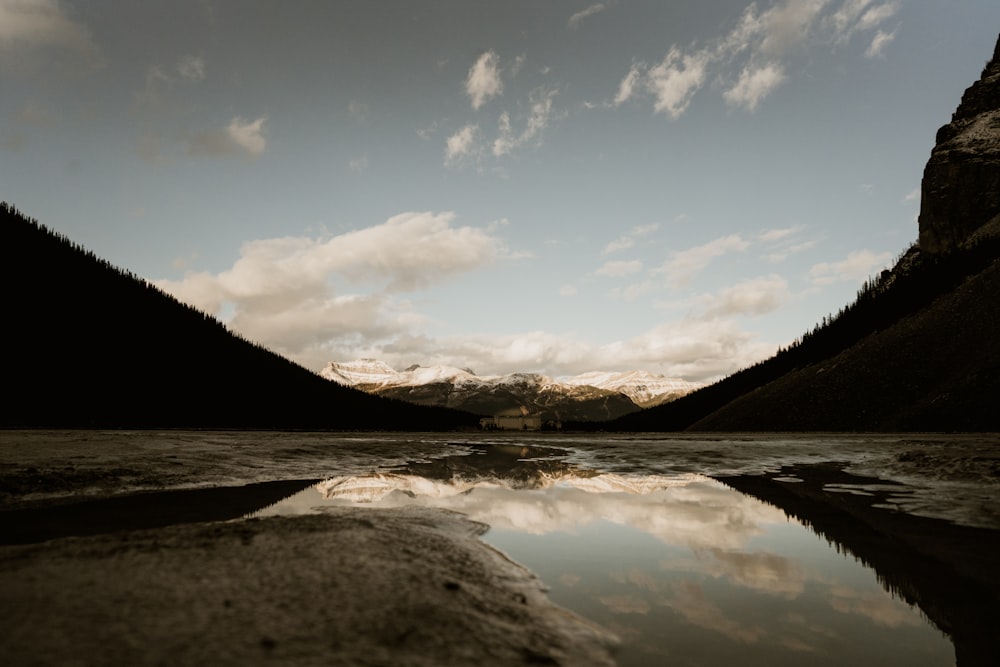 Specchio d'acqua vicino alla montagna sotto il cielo blu durante il giorno