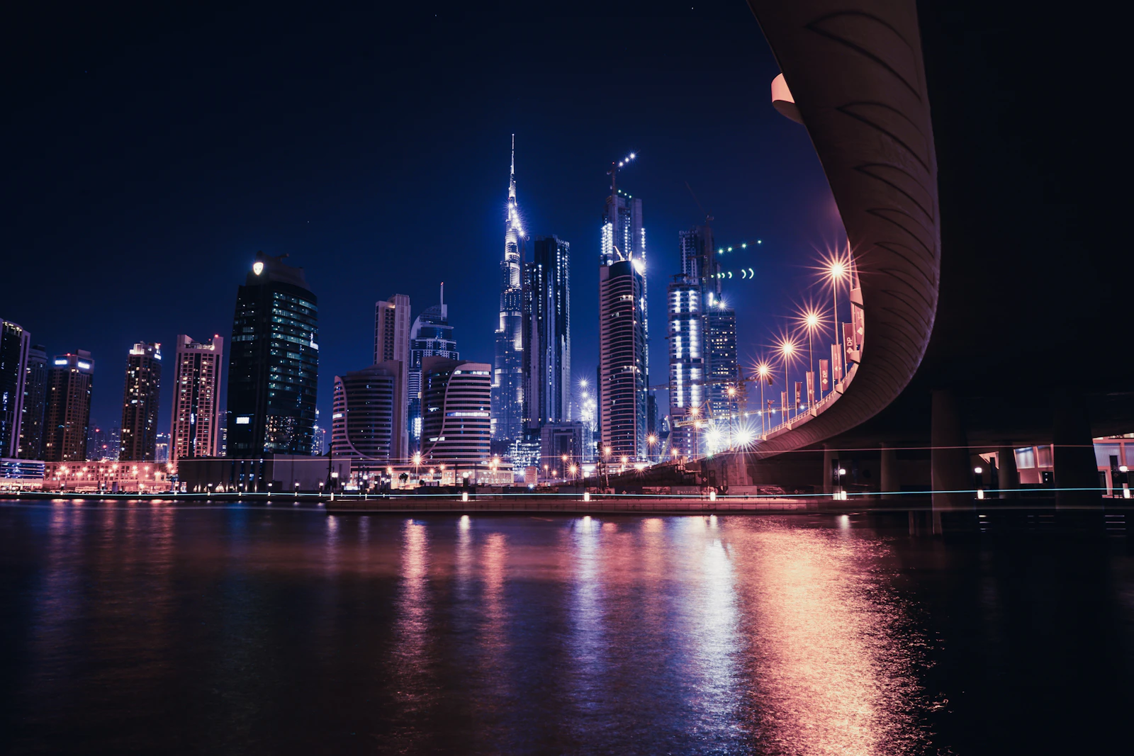 Downtown Dubai towers lit up at night above the water