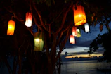 An evening scene with lanterns lighting up a peaceful gathering in a park.