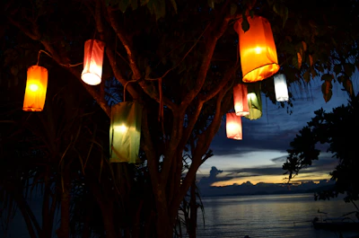 An evening scene with lanterns lighting up a peaceful gathering in a park.