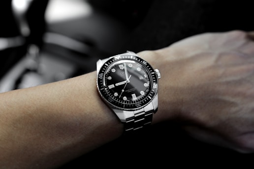 person hand with silver-colored watch
